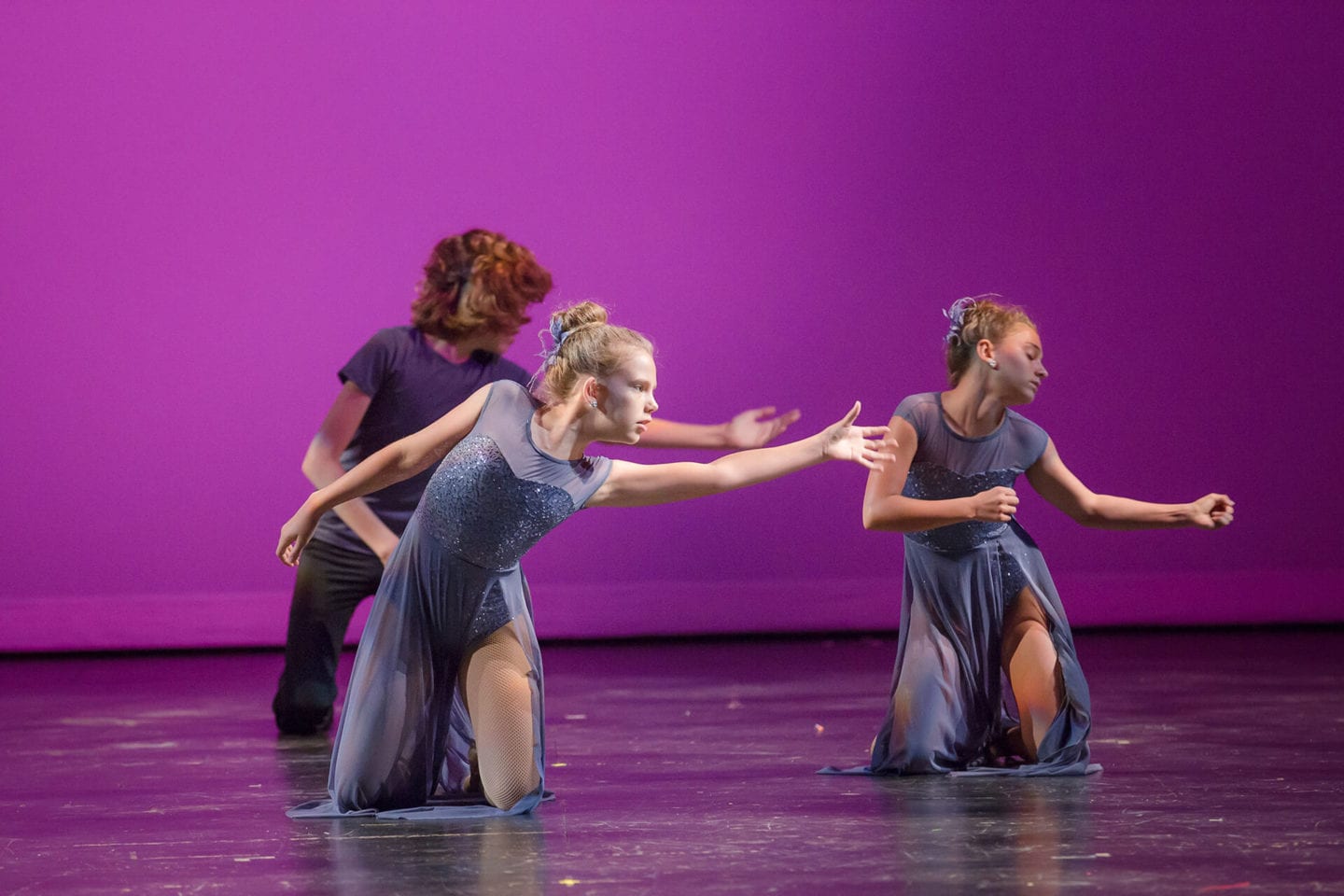 Contemporary dance class Temecula Three contemporary dancers on knees against purple background