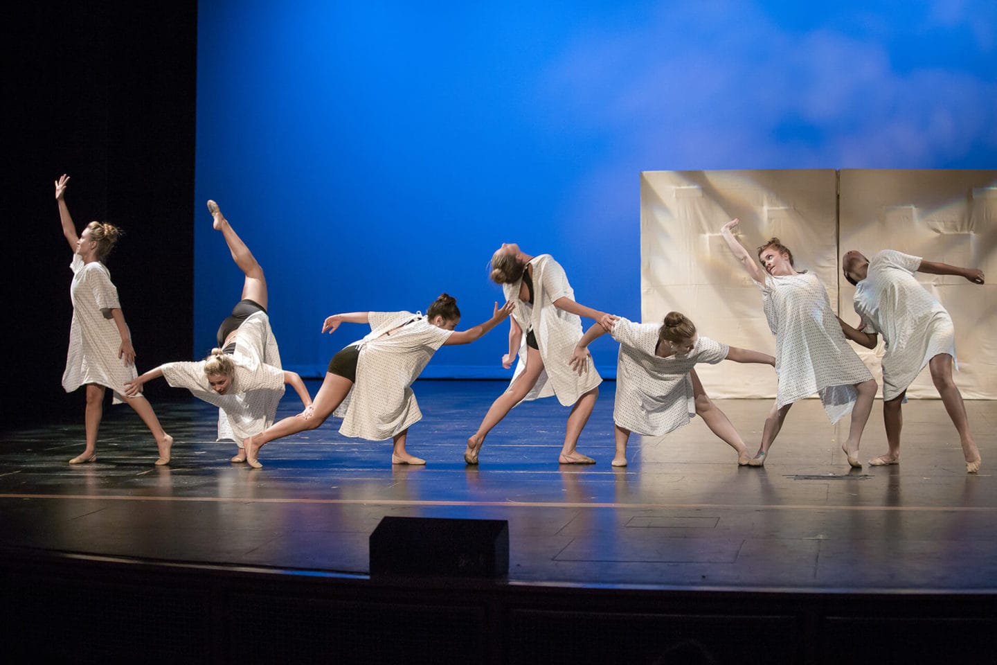 Lyrical dance class Temecula Dancers on stage wearing white against blue background